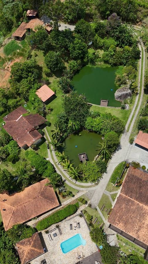 Aerial view of the lodge with its ponds, chalets and pool amid the forest
