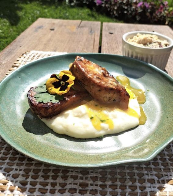 Plated dish with mash and an edible flower