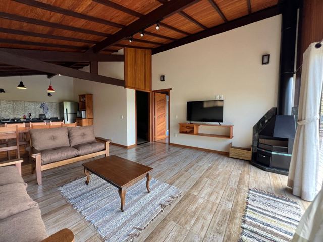 Chalet living room with sofas, fireplace and kitchen