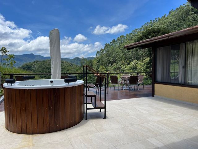Hot tub on the deck with umbrella and forest behind