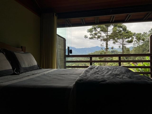 Bedroom opening onto araucarias and mountains