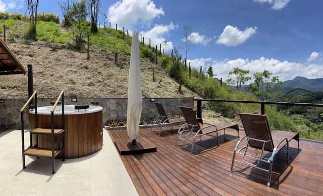 Hot tub and loungers on a deck facing the mountains